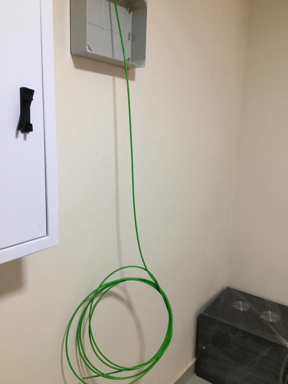 Fibre optic drop cable coiled below a wall termination box during an IT Guy Solutions installation