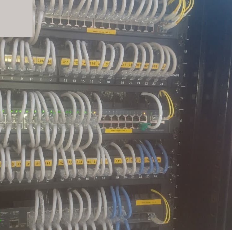 Labelled CAT6 patch cords dressed into network switches in a communications rack