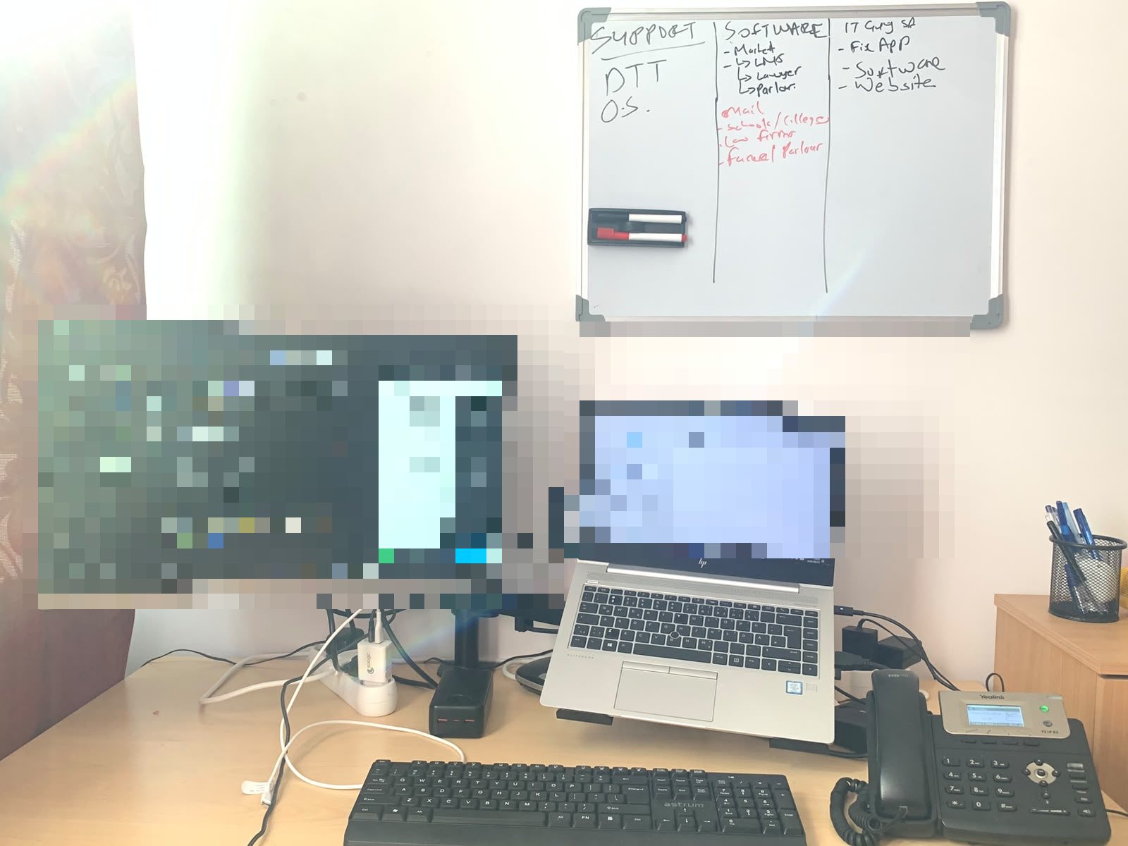 IT Guy Solutions remote support desk with dual screens, a laptop, desk phone and job board