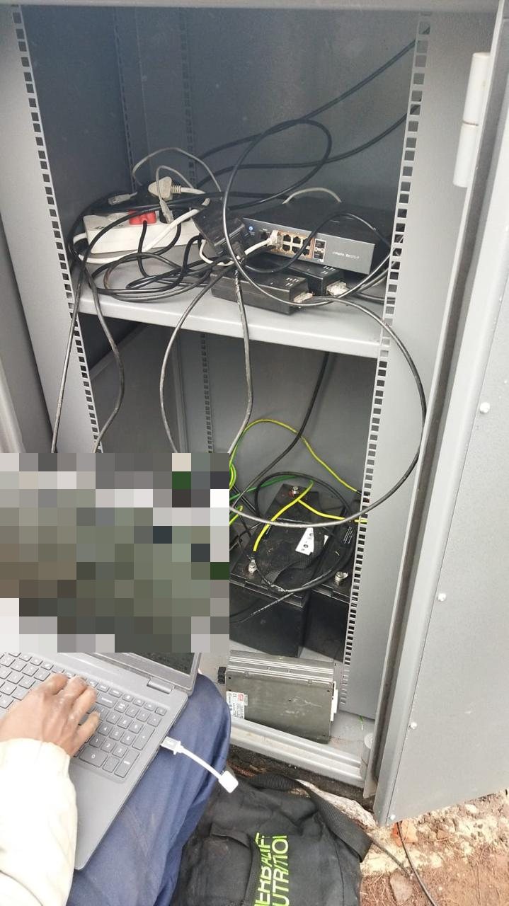 Open outdoor communications cabinet with radio, power and batteries being configured on site