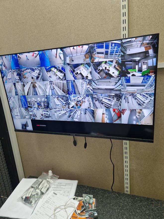 Wall-mounted CCTV monitor showing a multi-camera live view