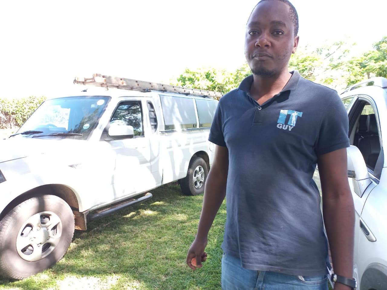 IT Guy Solutions technician standing with a service bakkie before a site visit