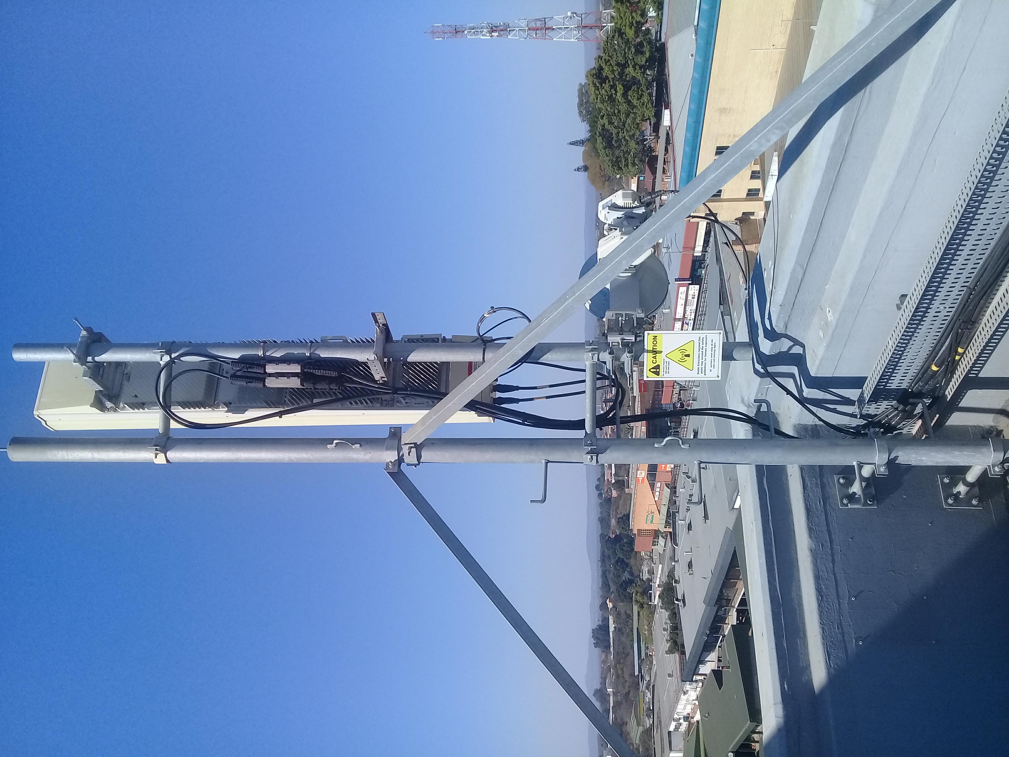 Rooftop wireless sector antenna and microwave dish on a commercial building