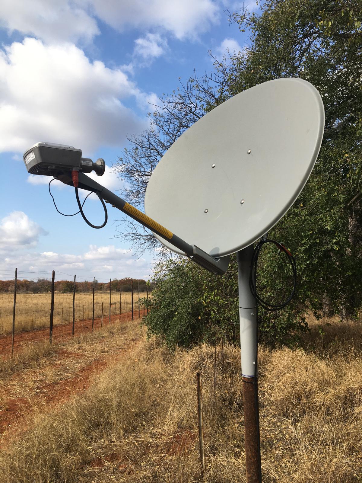 VSAT dish and radio on a pole at a rural fenced property