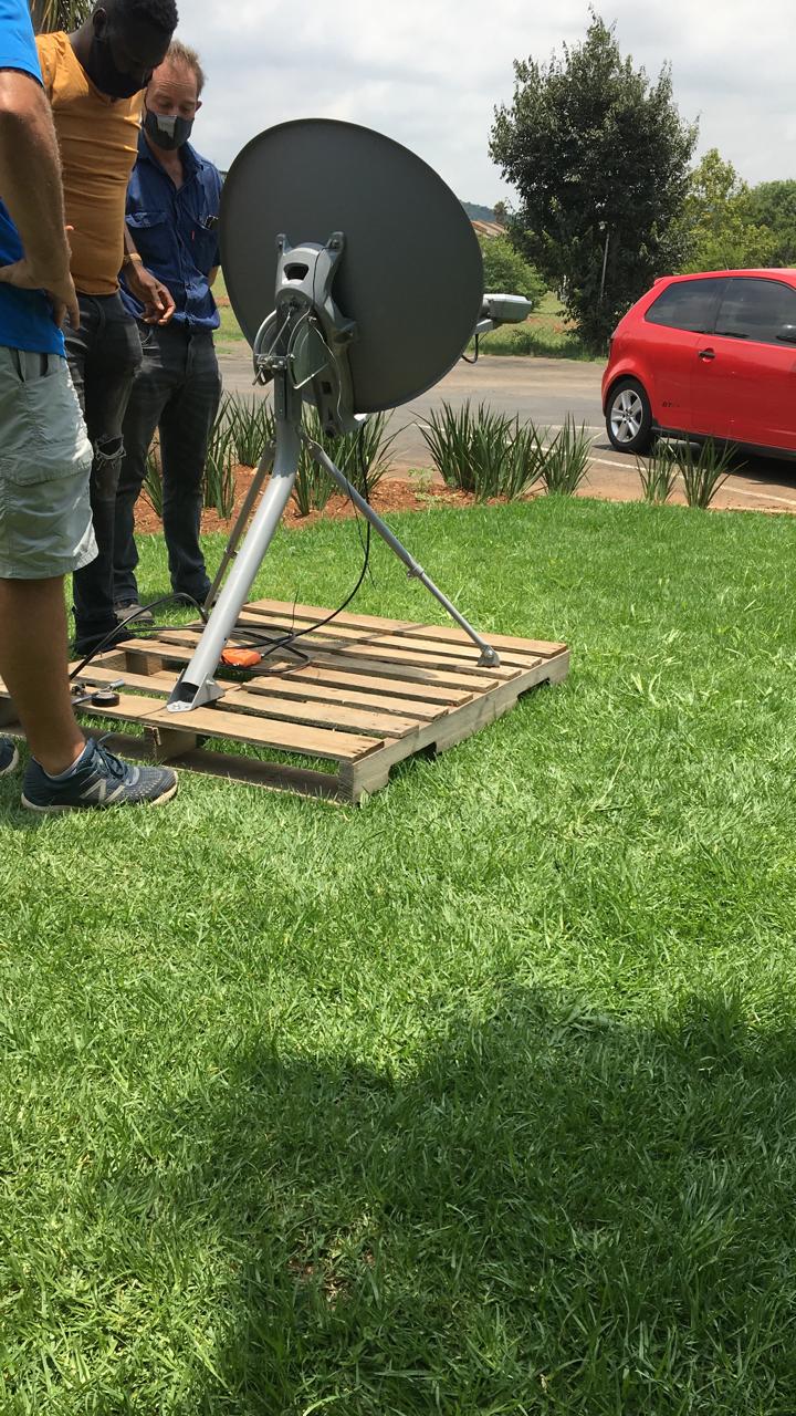 Technicians aligning a VSAT dish on a ground mount